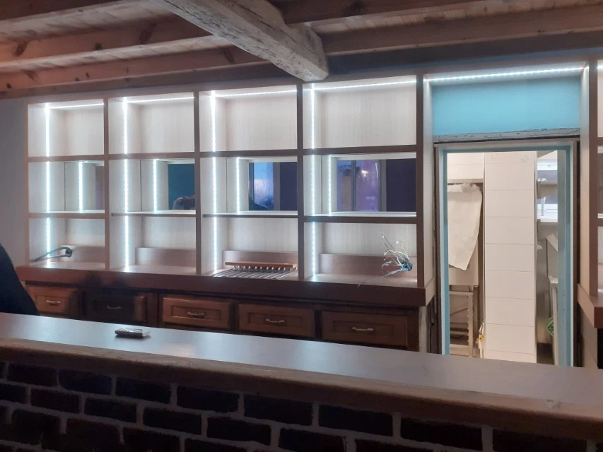 Atelier de menuiserie avec deux artisans en tabliers travaillant sur un projet commun