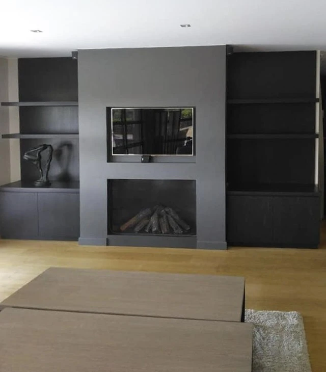 Atelier de menuiserie avec deux artisans en tabliers travaillant sur un projet commun