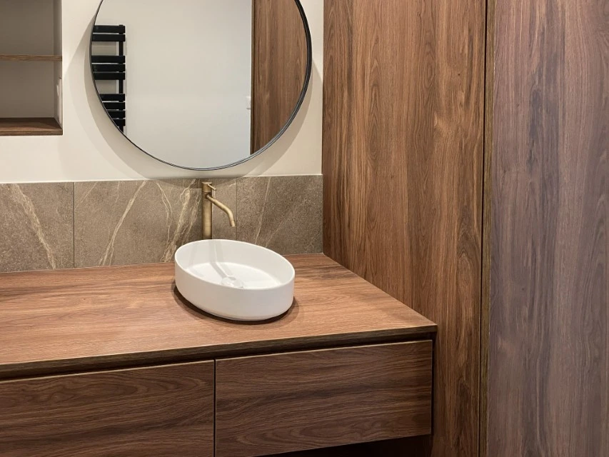 Atelier de menuiserie avec deux artisans en tabliers travaillant sur un projet commun