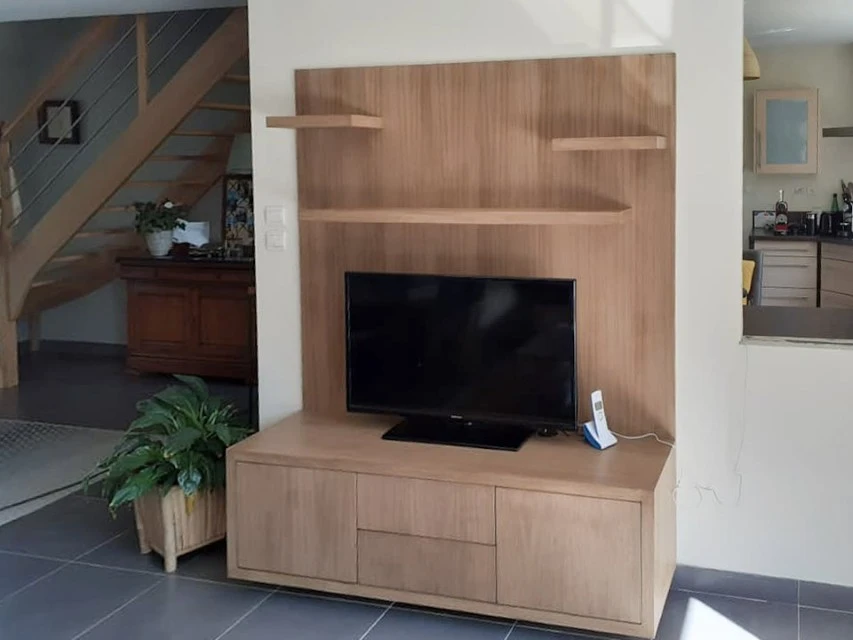 Petit studio élégant avec salon ouvert sur la cuisine et la chambre derrière un mur en verre et éclairé