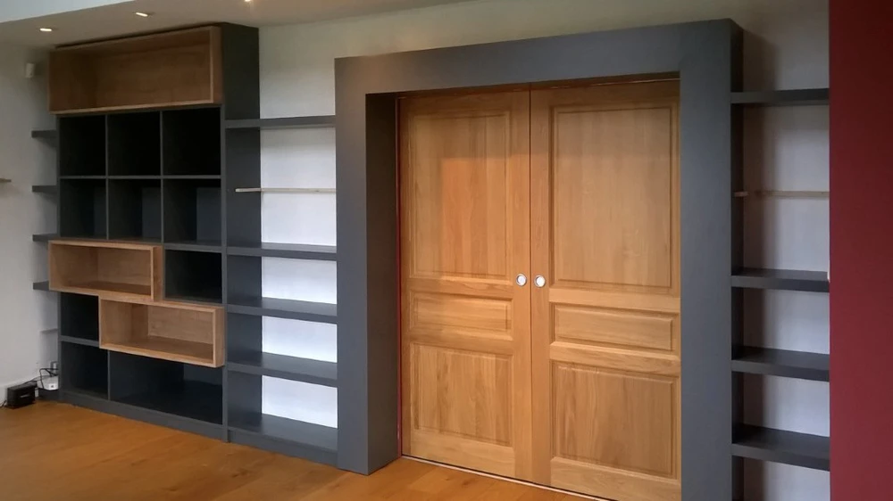 Chambre moderne avec lit gris équipé de tiroirs de rangement coulissants intégrés