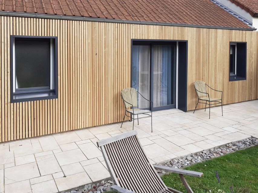 Construction de maison neuve extérieure à l'étape de la charpente en bois, échelle d'extension en aluminium soutenue contre le mur arrière, premiers jours sur le chantier résidentiel