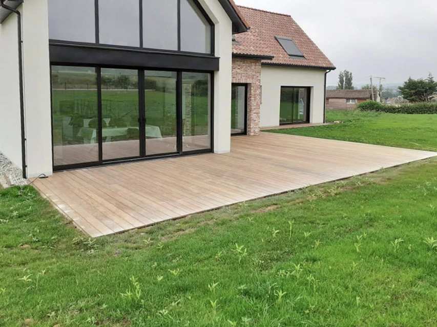 Construction de maison neuve extérieure à l'étape de la charpente en bois, échelle d'extension en aluminium soutenue contre le mur arrière, premiers jours sur le chantier résidentiel