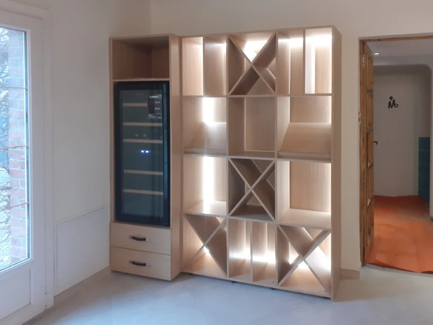 Petit studio élégant avec salon ouvert sur la cuisine et la chambre derrière un mur en verre et éclairé