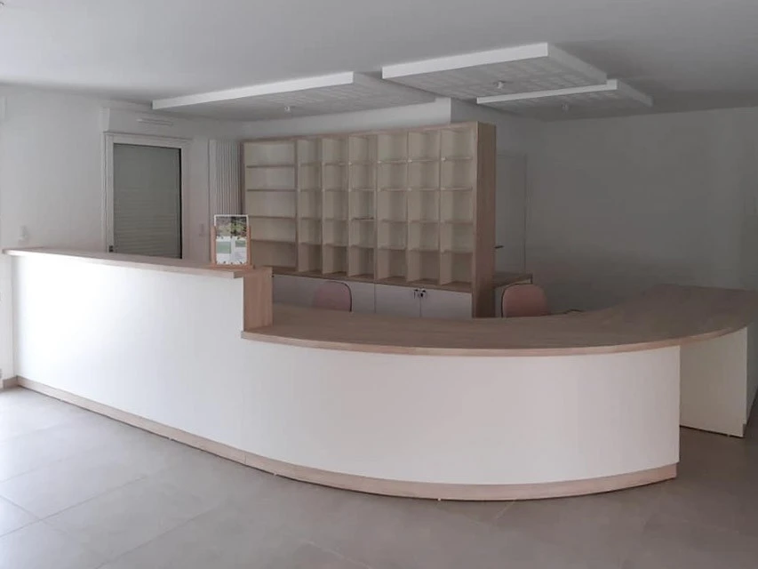 Petit studio élégant avec salon ouvert sur la cuisine et la chambre derrière un mur en verre et éclairé