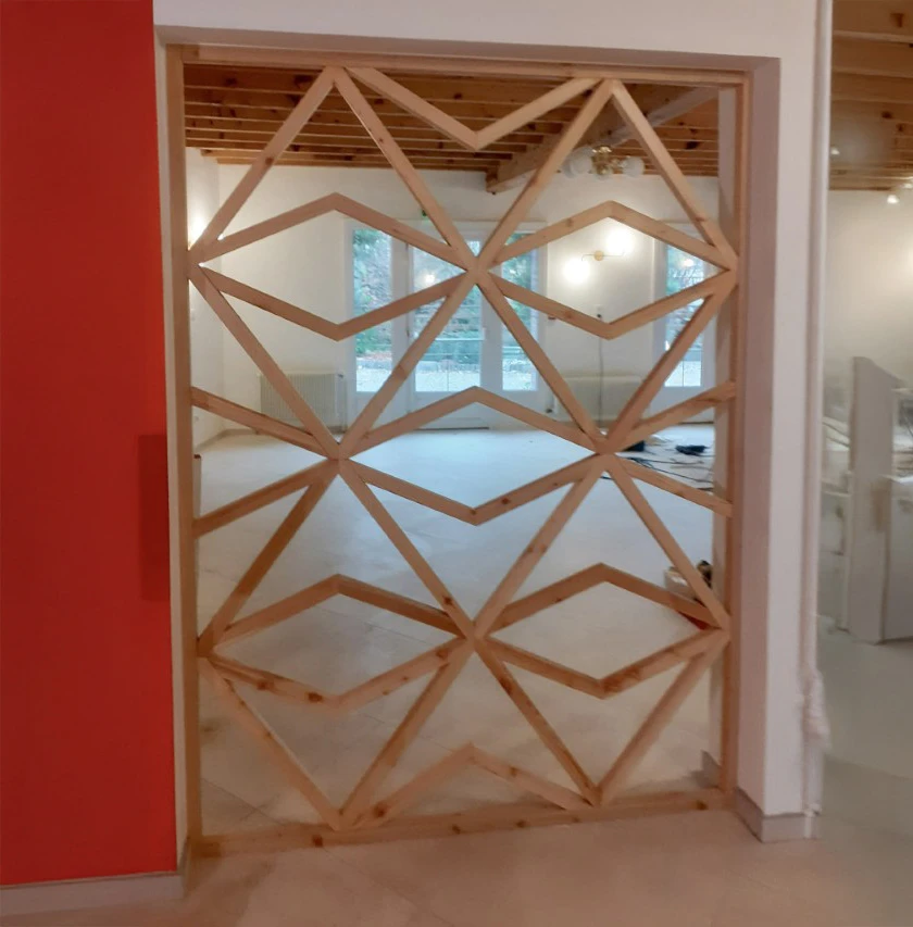 Artisan menuisier barbu en salopette examine une planche de bois dans son atelier